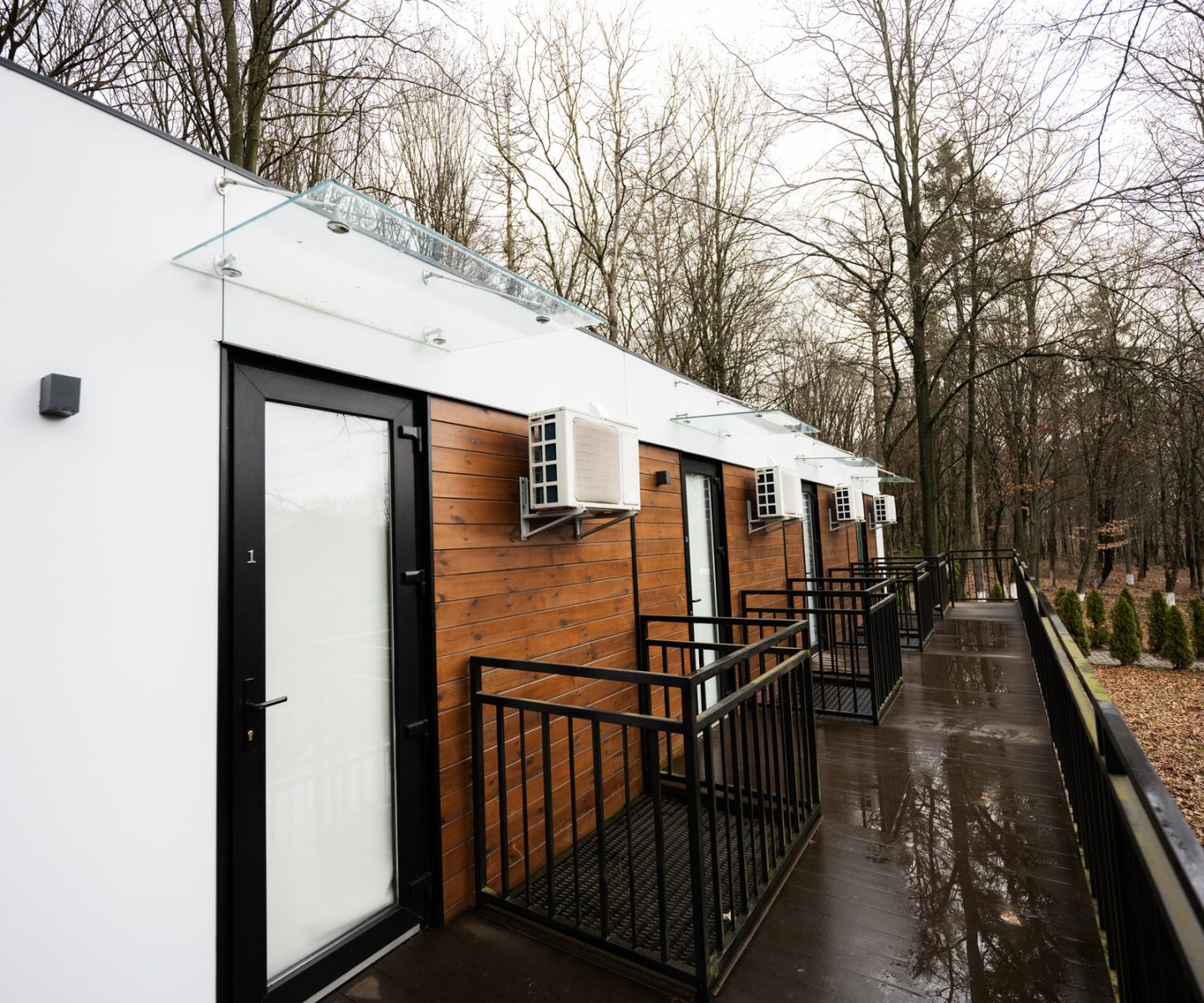 Terrace of one-storey modular houses in spring rainy forest.
